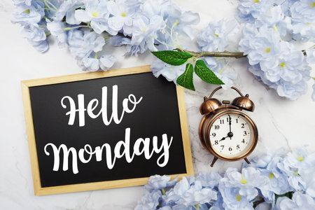 Hello Monday text on wooden blackboard and flower decoration on marble backgroundの写真素材
