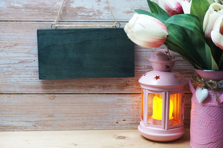Empty wooden hanging on wooden background with Pink lantern on wooden shelveの写真素材