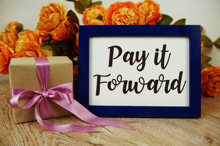 Pay it Forward typography text with gift box and flower on wooden backgroundの写真素材