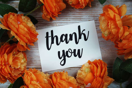 Thank you card with flower decoration on wooden backgroundの写真素材