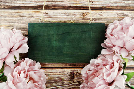 Pink peony flowers border frame on wooden backgroundの写真素材