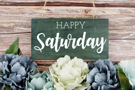 Happy Saturday typography text with pink flowers bouquet on wooden backgroundの写真素材