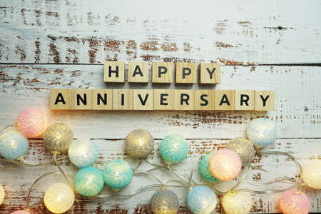 Happy Anniversary alphabet letter with LED cotton balls decoration on wooden backgroundの写真素材