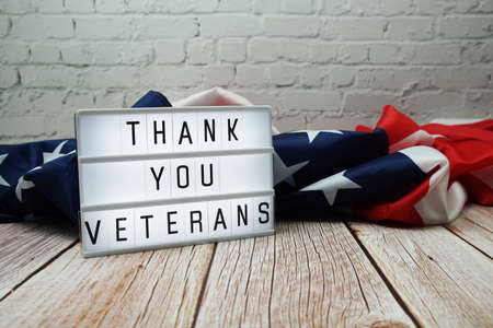 Thank You Veterans word in lightbox and American flag on wooden backgroundの写真素材