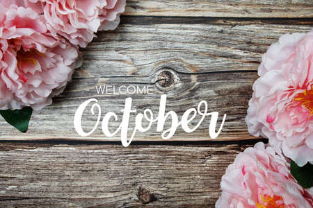 Welcome October typography text with peony flowers on wooden backgroundの写真素材
