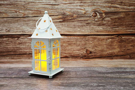 White Lantern decorative with candles with space copy on wooden backgroundの写真素材