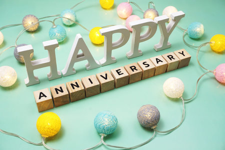 Happy Anniversary alphabet letter with LED cotton balls on green background