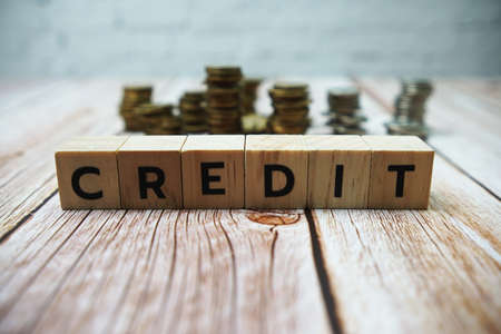 Credit alphabet letter and coins on wooden backgroundの写真素材