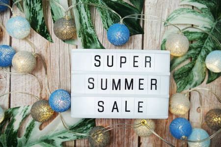 Super Summer Sale text in light box with LED cotton balls decorated on wooden backgroundの写真素材