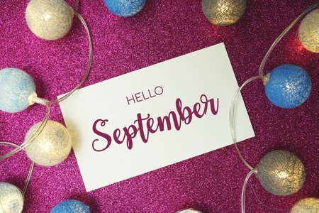 Hello September typography text with LED cotton ball on pink glitter backgroundの写真素材