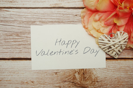 Happy Valentines day typography text with Flower and Rattan Heart on wooden backgroundの写真素材