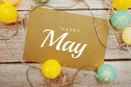 Happy May typography text with LED cotton ball on wooden backgroundの写真素材
