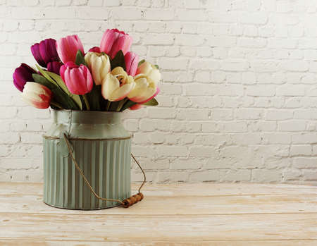 Tulip flower in metal vase home decoration on white bric wall backgroundの写真素材