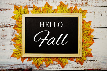 Hello Fall text on blackboard with LED pumkin decorate on wooden background