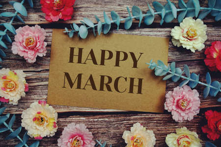 Happy March typography text on paper card decorate with flower on wooden backgroundの写真素材