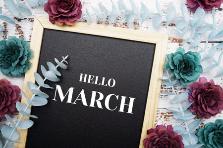 Hello March typography text and flower dcoration on blackboard background