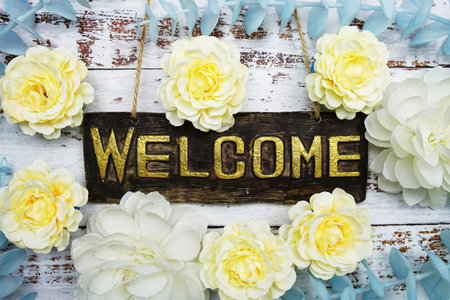Welcome Sign with flowers frame decorate on wooden background