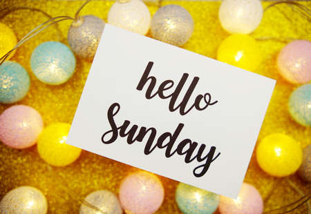 Hello Sunday text on paper card with LED cotton balls decorate on yellow backgroundの写真素材