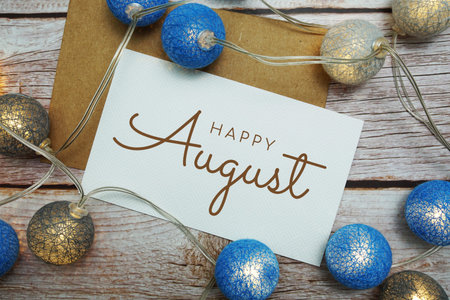 Happy August card typography text with LED cotton ball on wooden background