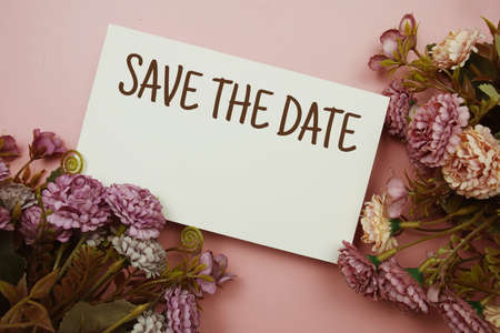 Save the Date typography text with flowers on pink backgroundの写真素材