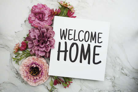 Welcome Home text with pink flower bouquet on marble backgroundの写真素材