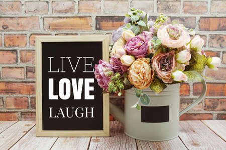 Live Love Laugh text on Blackboard and flower bouquet decoration wooden backgroundの写真素材