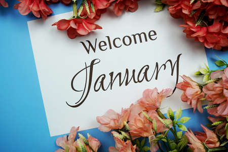 Welcome January text with Pink Flower frame on blue backgroundの写真素材