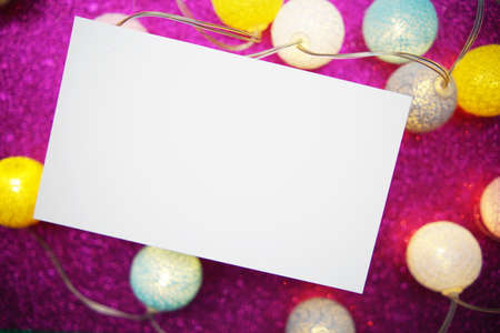 Empty paper card mockup and LED cotton balls decoration on pink bokeh backgroundの写真素材