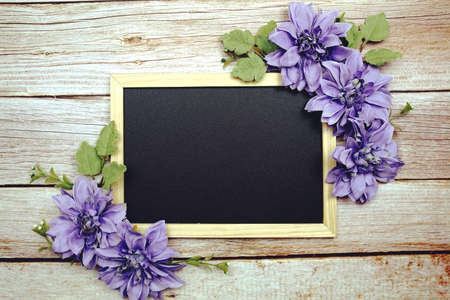 Empty Blackboard with flower decorate on wooden backgroundの写真素材