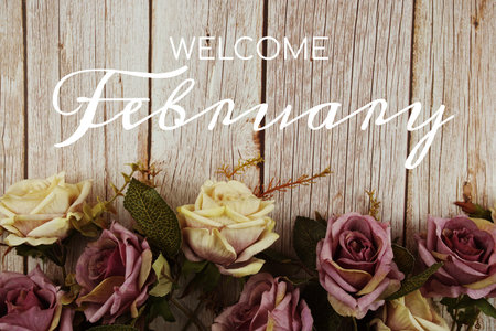 Welcome February typography text with rose flowers bouquet on wooden background