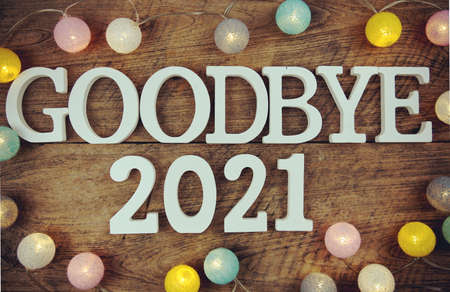 Goodbye 2021 alphabet letters and LED cotton ball decoration on wooden backgroundの写真素材