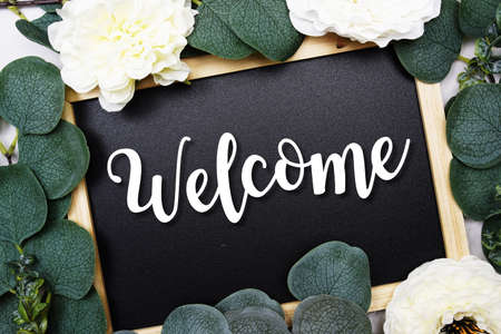 Welcome text on blackboard and eucalyptus leaves decoration on marble backgroundの写真素材