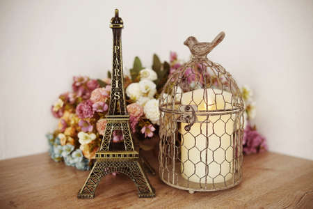 Home decor Eiffel tower, LED candle light and artificial flower on wooden shelve backgroundの写真素材