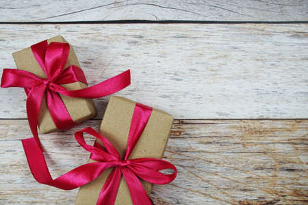 Gift boxes with pink ribbon on wooden backgroundの写真素材