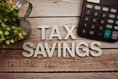 Tax Savings alphabet letters with calculator on wooden backgroundの写真素材