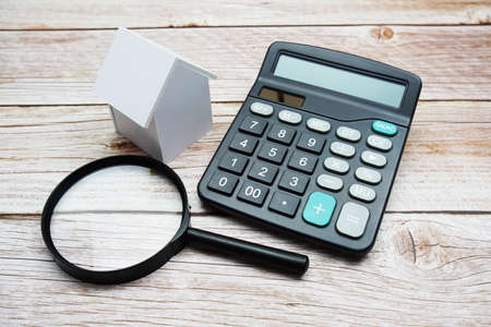 White Model House with magnifying glass and calculator on wooden background, realestate conceptの写真素材