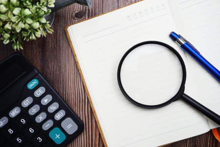 Planning schedule with magnifying glass and calculator on wooden background
