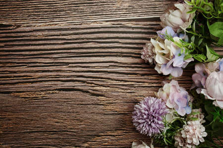 Frame of flowers with wooden banner for text on wooden backgroundの写真素材