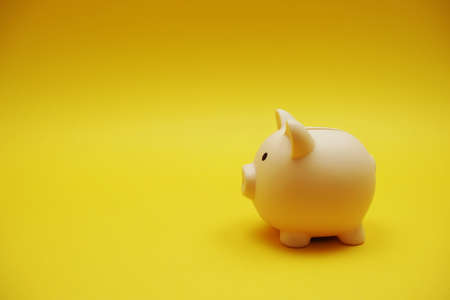 Piggy banks saving with space copy on yellow backgroundの写真素材