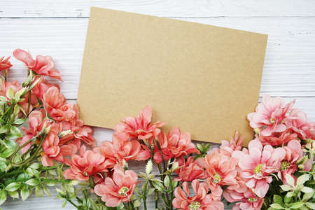 Empty paper card with pink daisy flower flat lay on wooden backgroundの写真素材