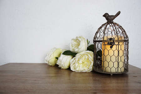Bird Cage with Candle light and flower decoration on wooden backgroundの写真素材