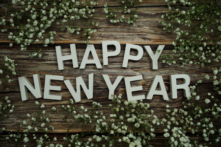 Happy New Year alphabet letters with flowers on wooden backgroundの写真素材