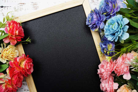 Empty blackboard with flower on wooden backgroundの写真素材