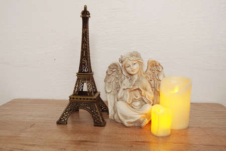 Wooden shelves decorated with Eiffel tower souvenir, LED candle light and little angel statueの写真素材