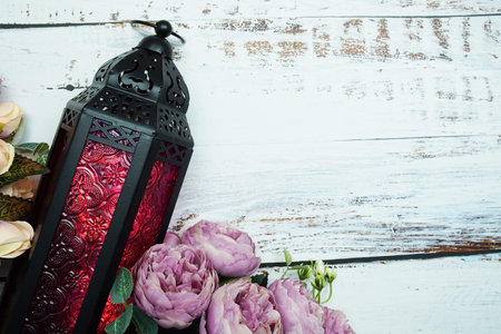Black Moroccan Arabic lantern with flower on white table background