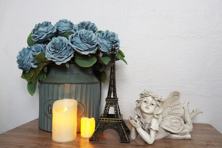 Wooden shelves decorated with Eiffel tower souvenir, LED candle light and little angel statueの写真素材
