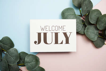 Welcome July text message with green leave on blue and pink backgroundの写真素材