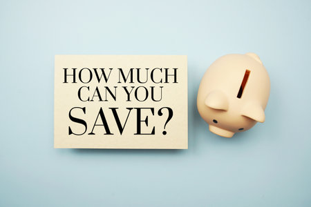 How much can you save? text message and piggy bank on blue backgroundの写真素材