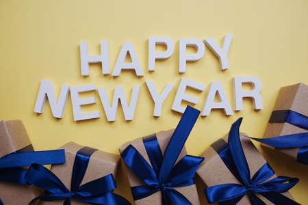 Happy New Year alphabet letters with gift boxes on yellow backgroundの写真素材