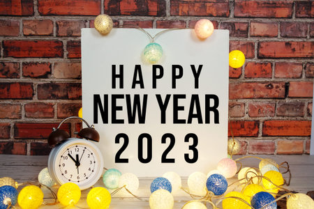 Happy New Year 2023 text message with alarm clock and LED cotton balls decoration